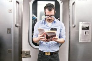 Мужчина читает в транспорте